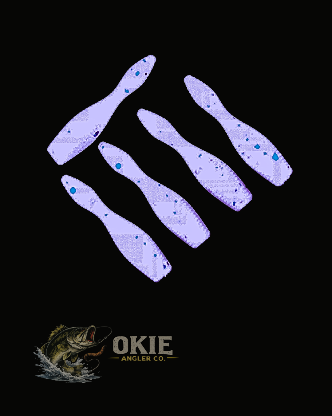 Five light purple soft plastic fishing lures with blue glitter splatter details, arranged on a black background with the Okie Angler Co. logo at the bottom.