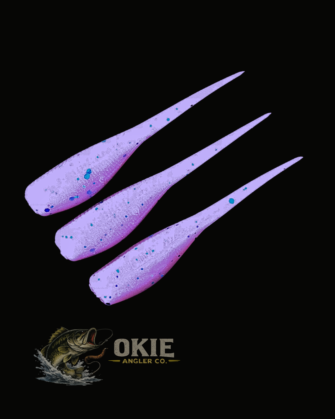 Three purple and blue speckled fishing lures arranged diagonally on a black background, with the Okie Angler Co. logo at the bottom.
