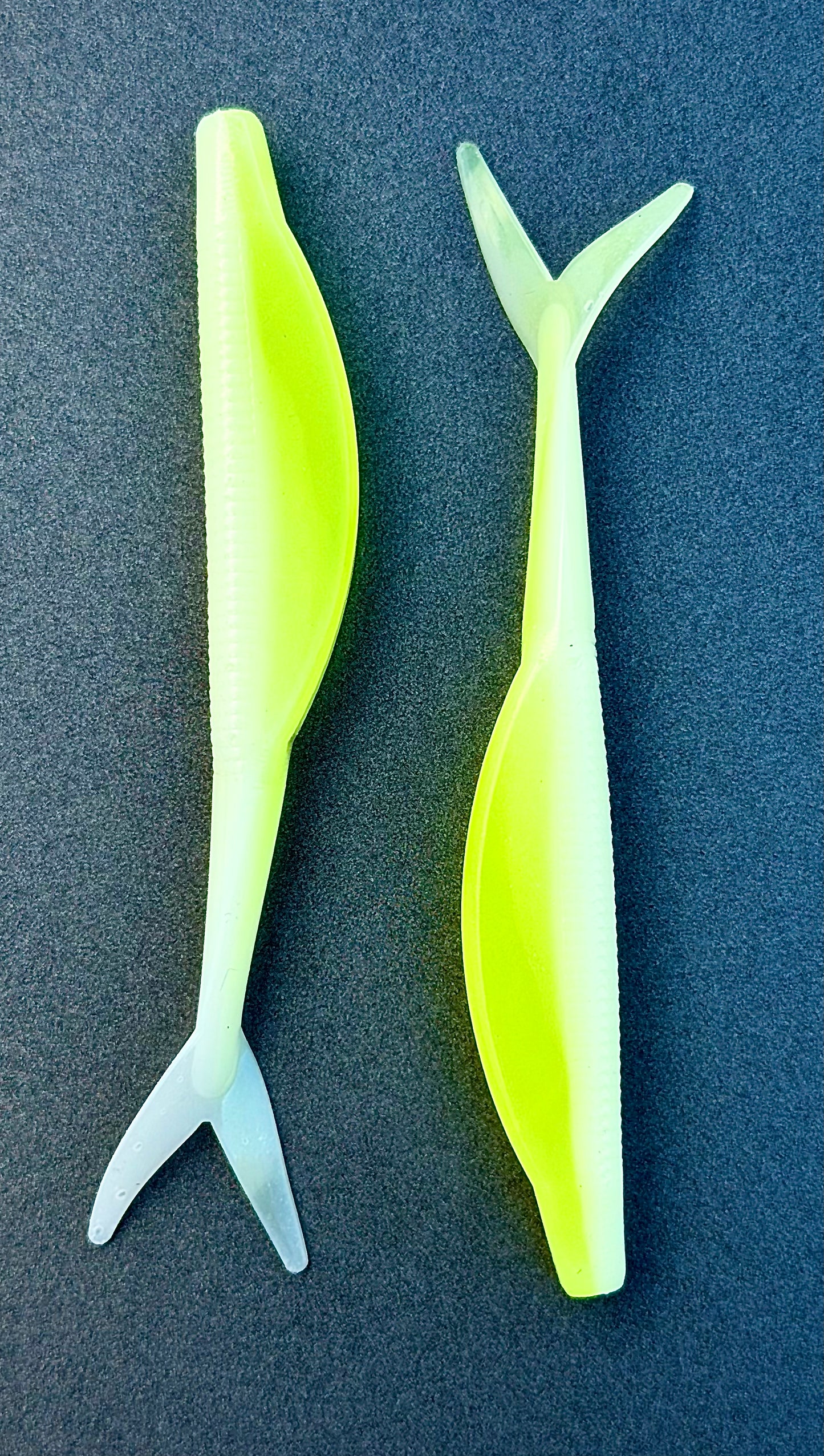 Two neon green fishing lures on a dark blue background