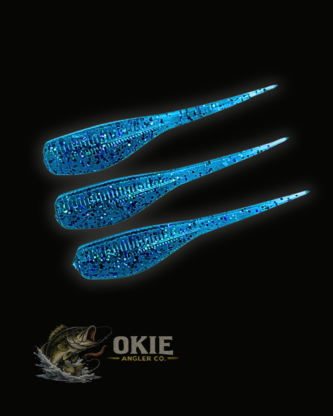 Three blue glitter soft plastic fishing lures with ribbed bodies and pointed tails, arranged diagonally on a black background with the Okie Angler Co. logo at the bottom.