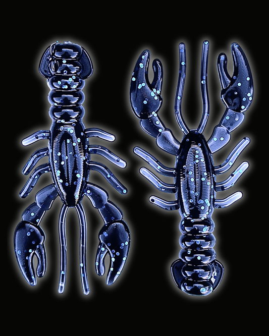 Two Okie Angler Co 3.4" Glory Craws in the color Okie Midnight (dark blue with blue sparkles) - crawfish-style fishing lures on a black background.