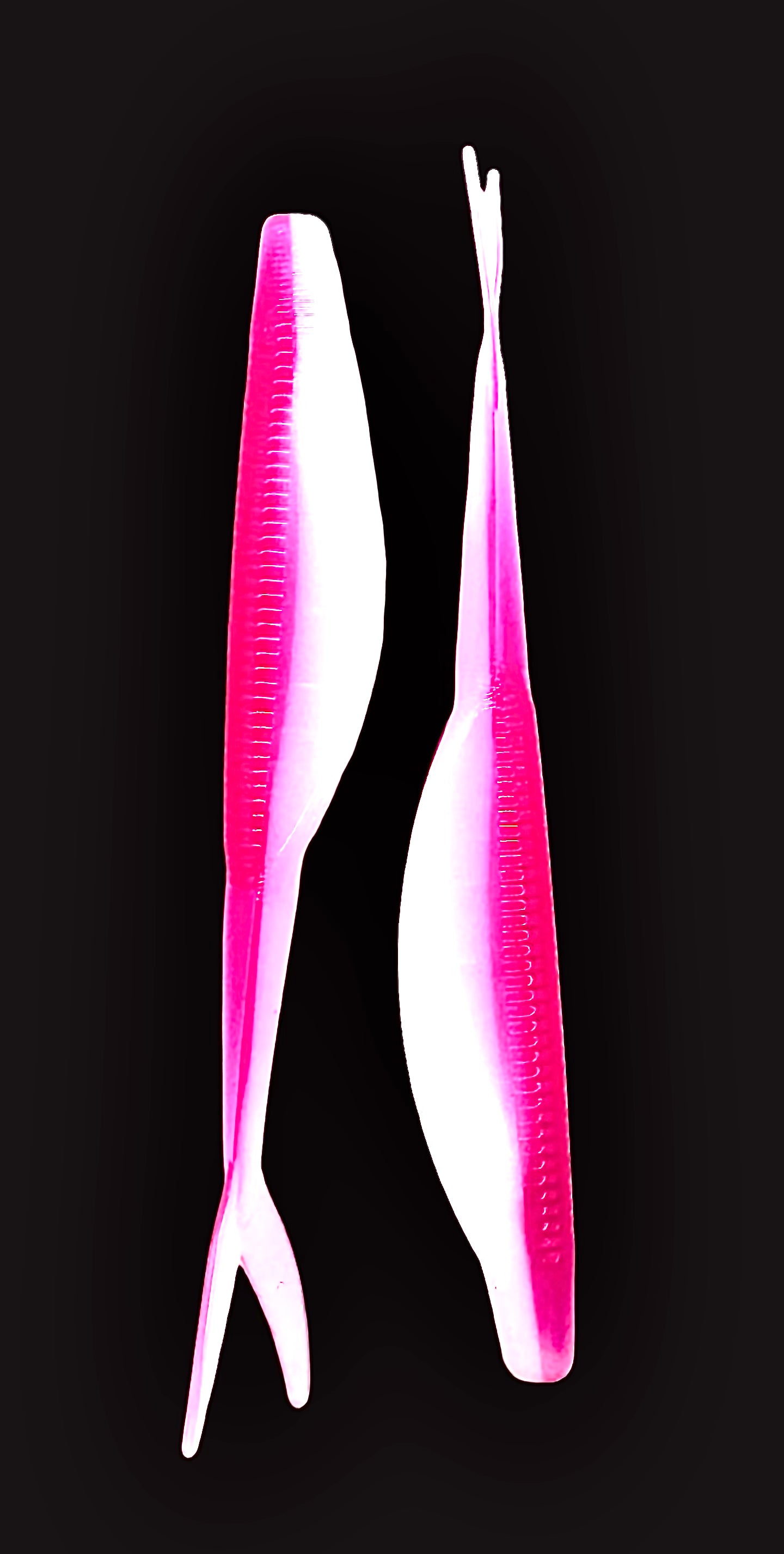Two pink and white fishing lures on a black background