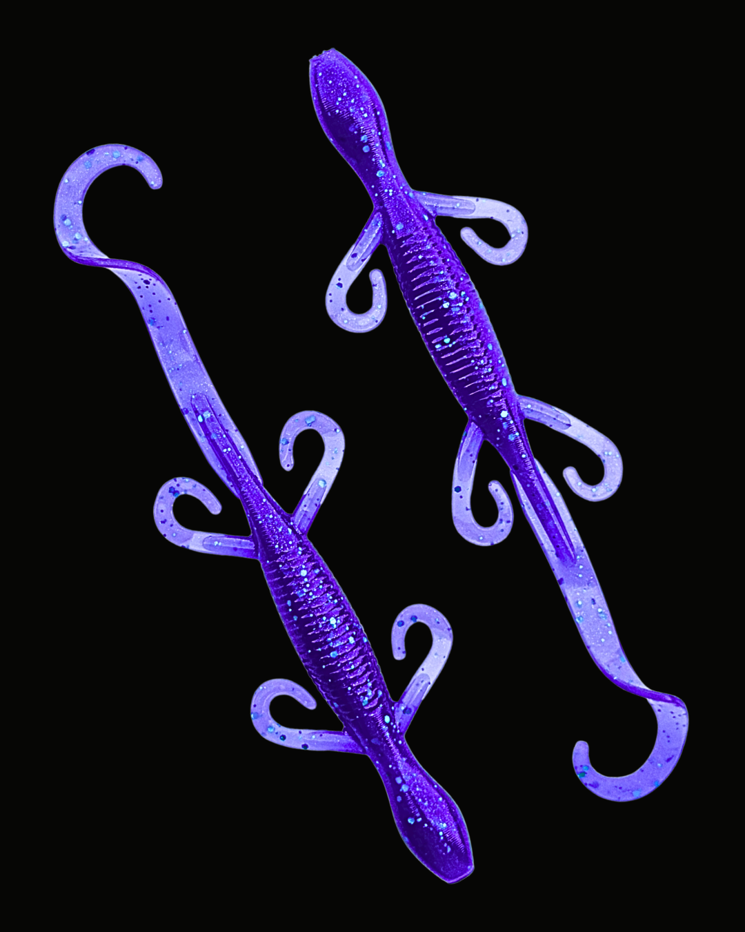Two purple glitter soft plastic paddle tail fishing lures on a solid black background.