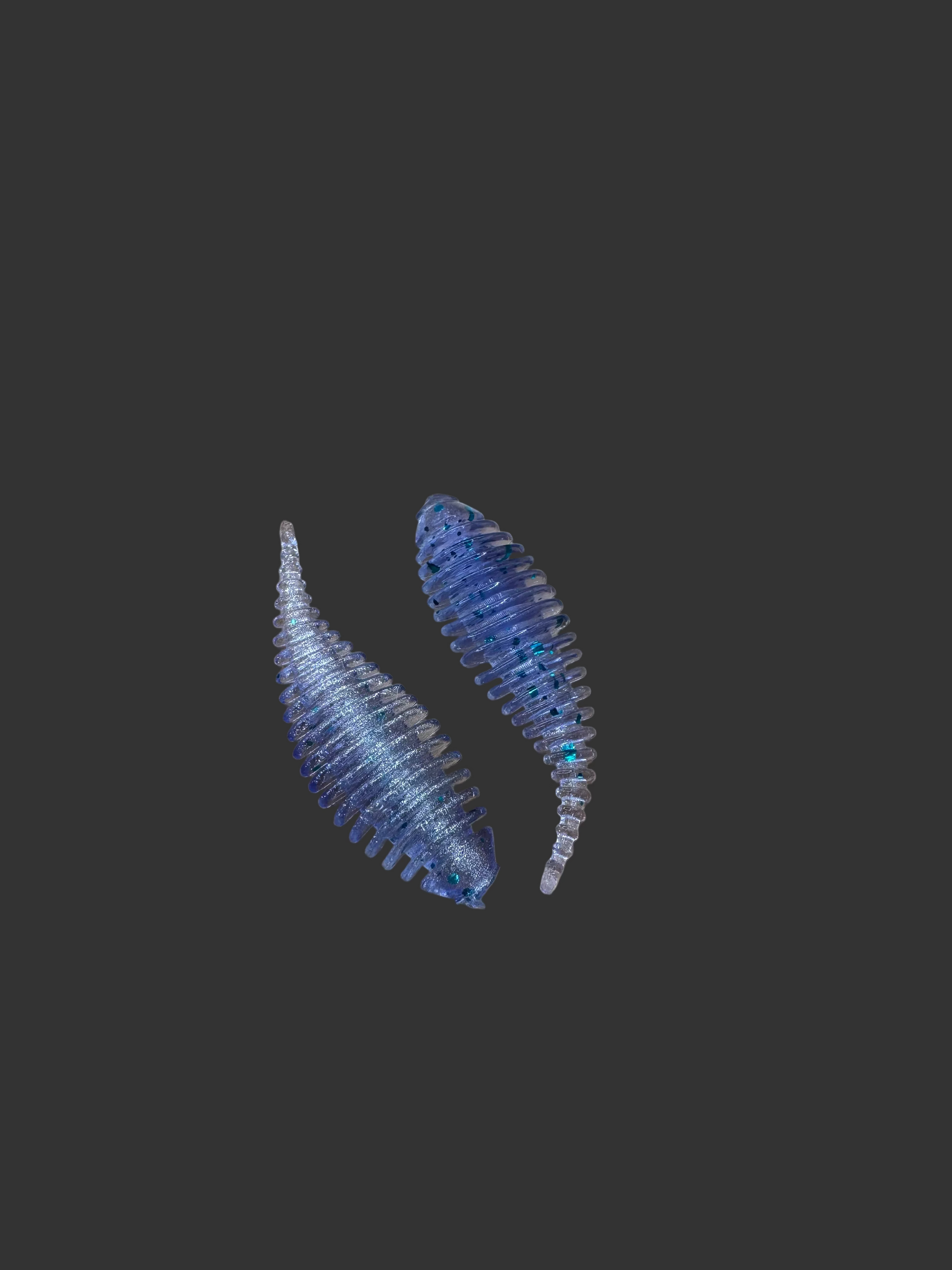 Two blue and clear fishing lures on a wooden surface