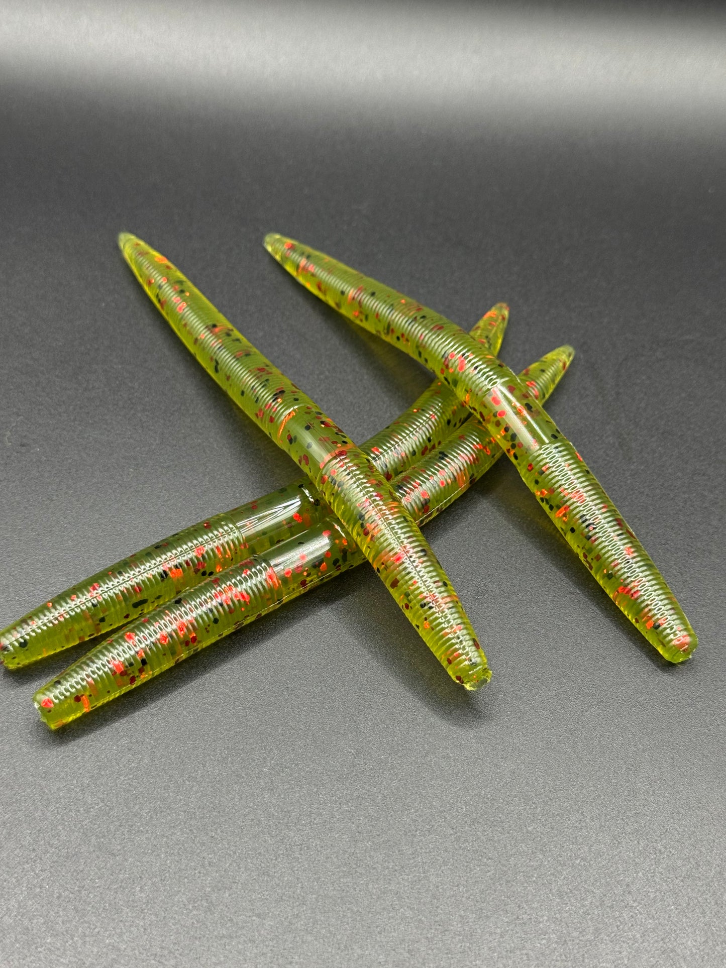 Okie Angler Co 5" Watermelon Red Twister Sticks Senko-style stick baits for bass fishing on a black background.